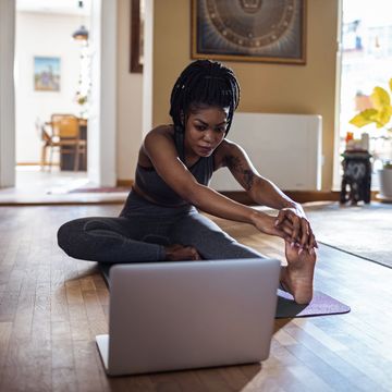 Woman learning the janu sirsasana pose close up of a young woman learning yoga online from her laptop